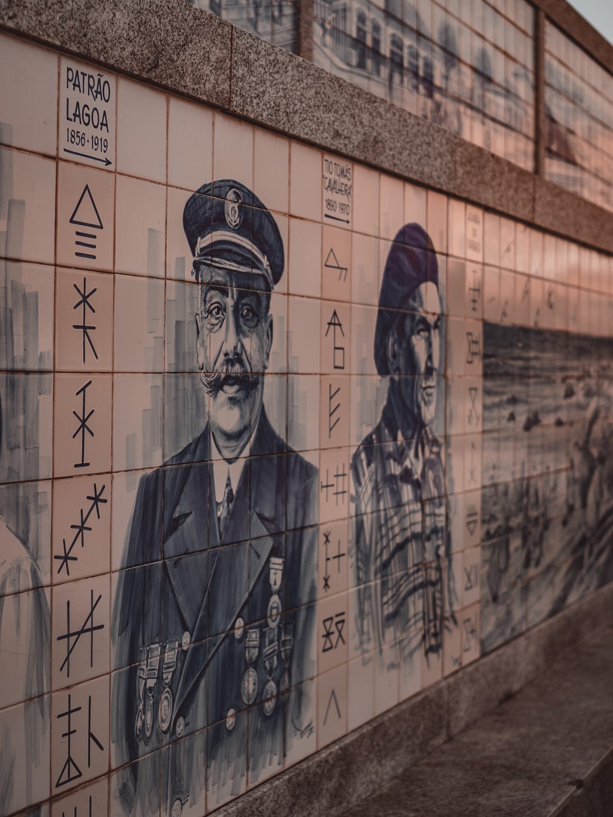 Painel de azulejos com retratos de pescadores poveiros e as respetivas siglas